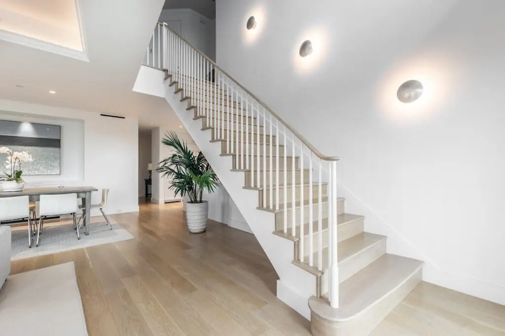 Renowned Group bright modern staircase with light wood floors and minimalist design