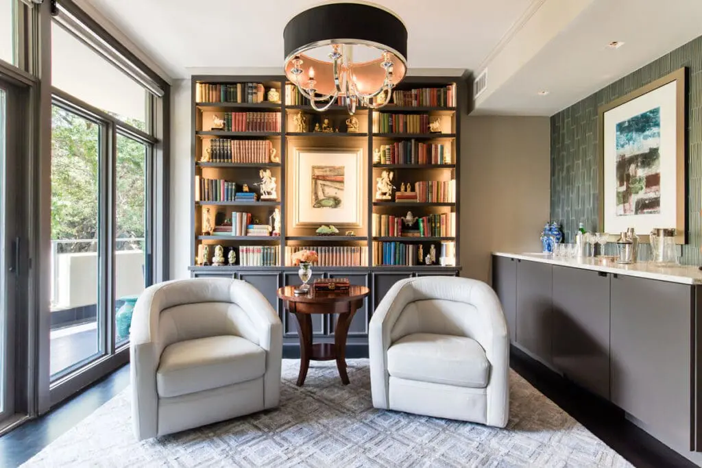 Renowned Group elegant home library with built in bookshelves and bar area