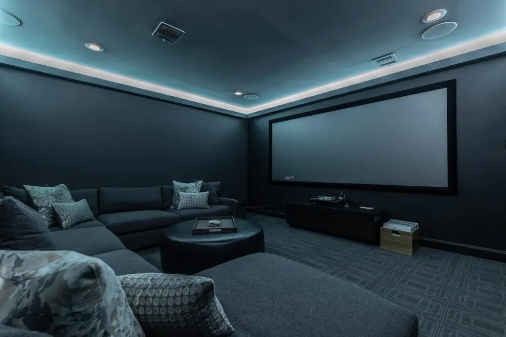 Renowned Group modern home theater room with dark walls and ambient led lighting