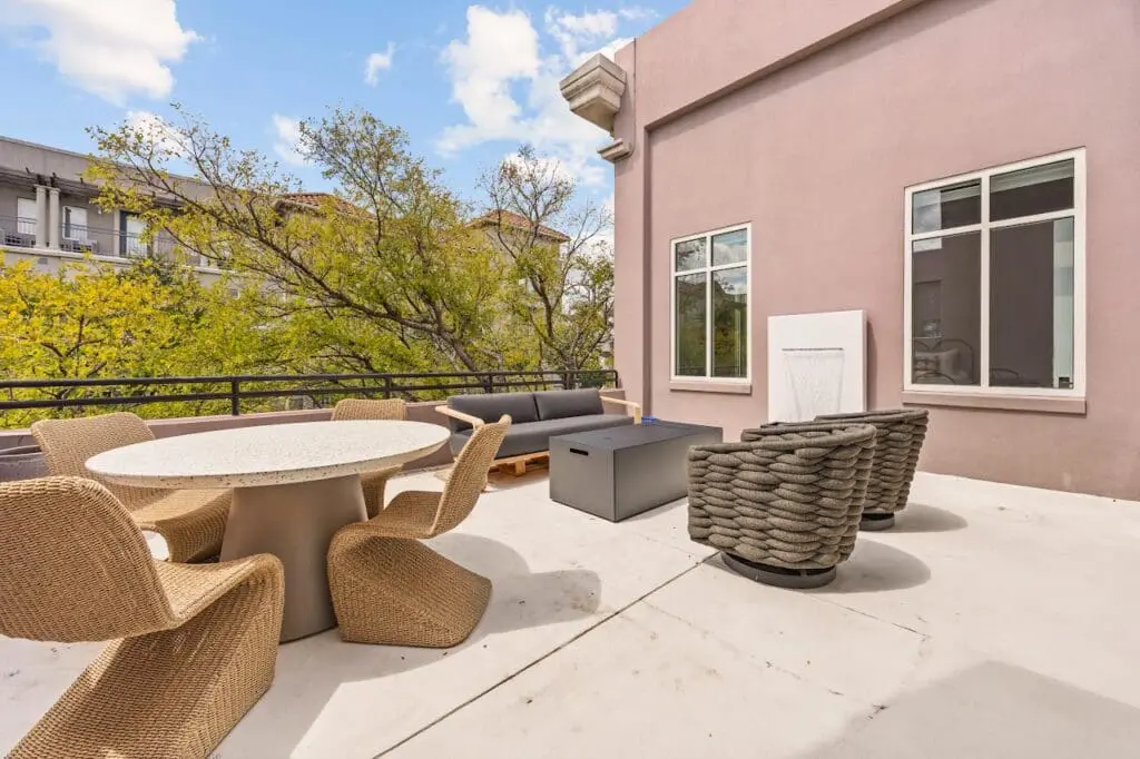 Renowned Group modern rooftop terrace with woven lounge furniture and dining area