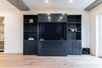 Multi-Use Entertainment Center. The entertainment center was by r custom built by Renowned Cabinetry and holds a remote-controlled Zoom-Room Murphy bed system that converts the room from a living room into a guest room!