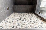The Botany Bay Sliced Pebble shower floor adds an extra flair to this condo’s master bathroom