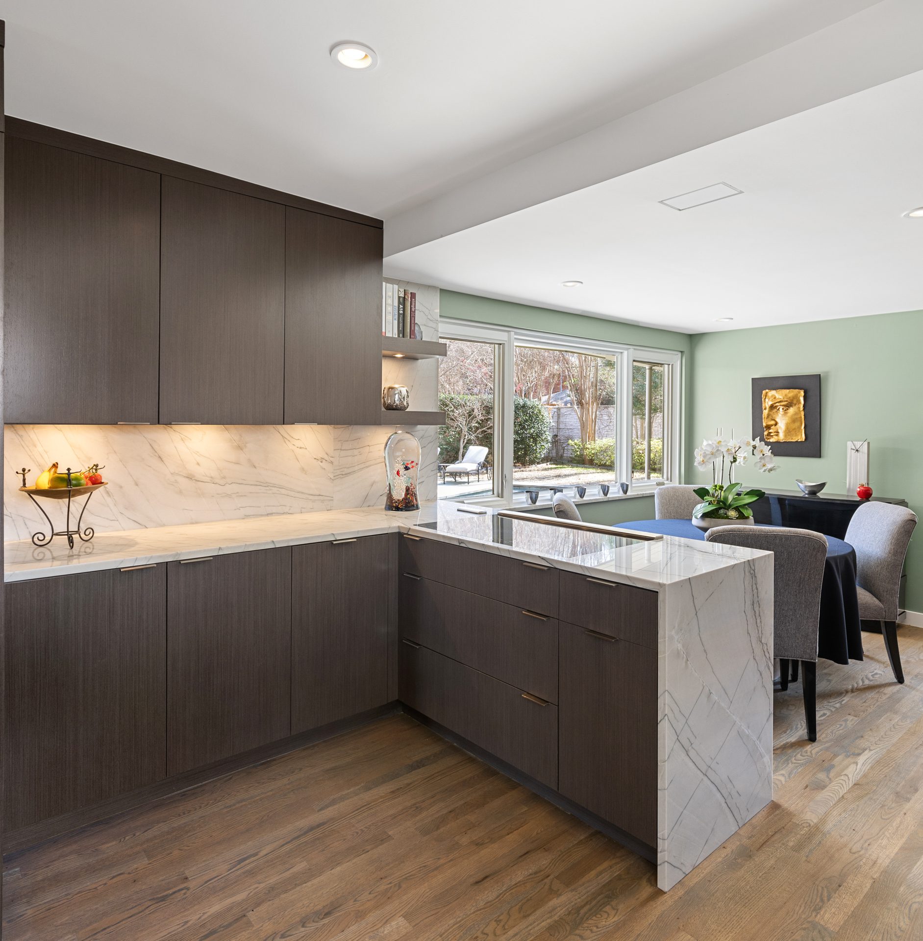 The New kitchen features a peninsula with a natural stone countertop and waterfall