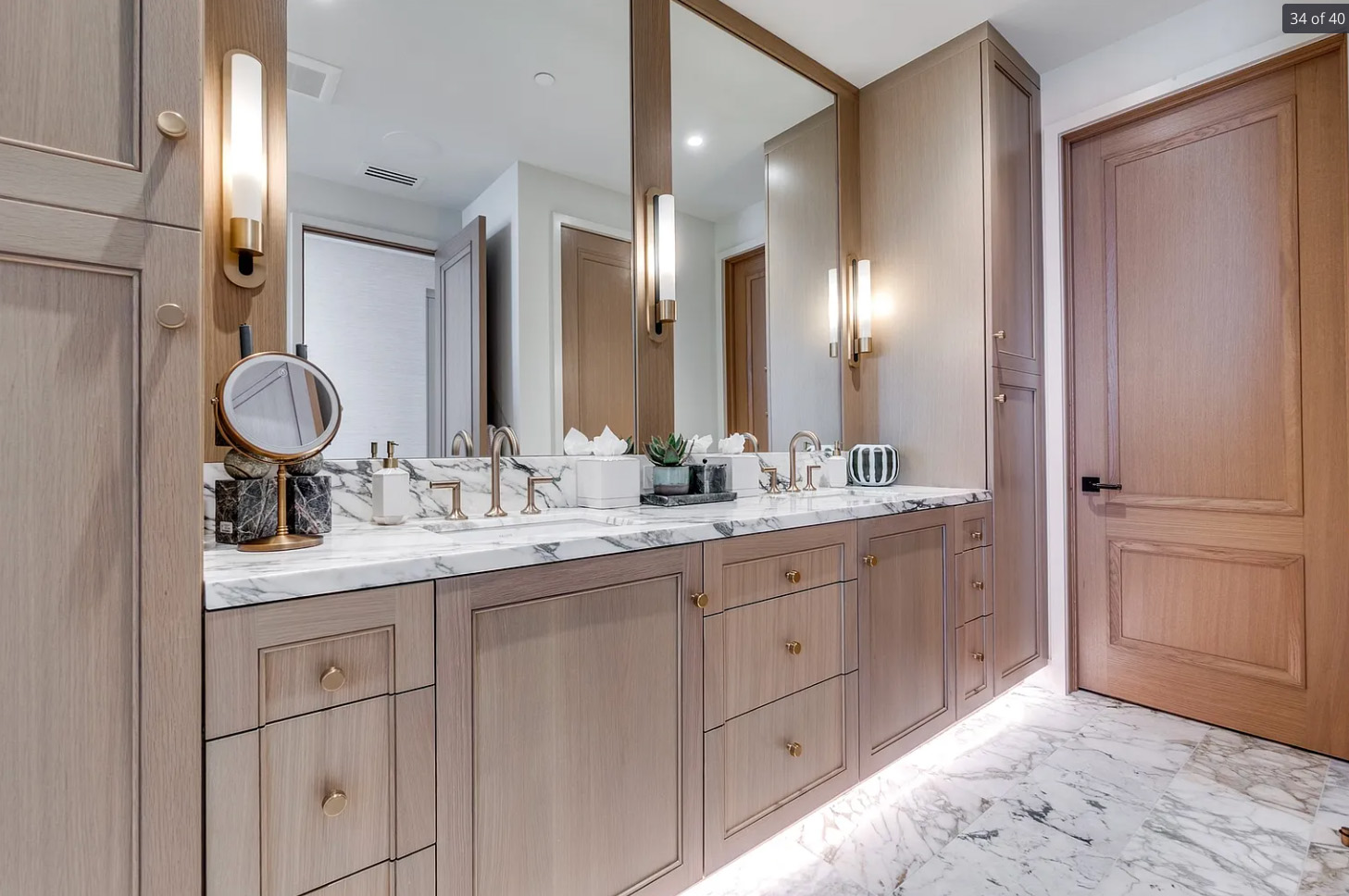 Bathroom remodel in Dallas by Renowned Group double vanity with marble countertop and gold sconces