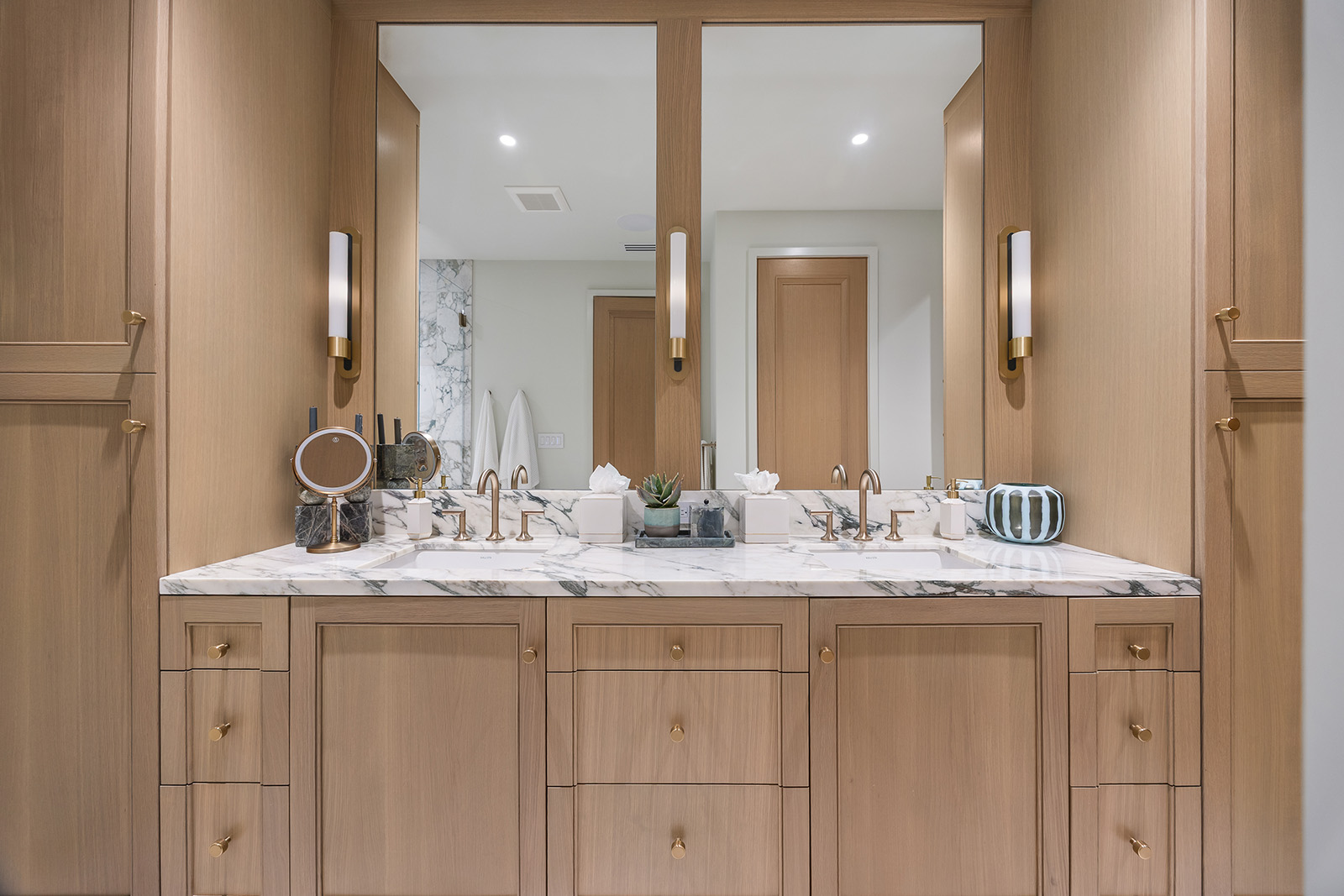 Bathroom remodel in Dallas by Renowned Group double vanity with oak cabinetry and marble countertop