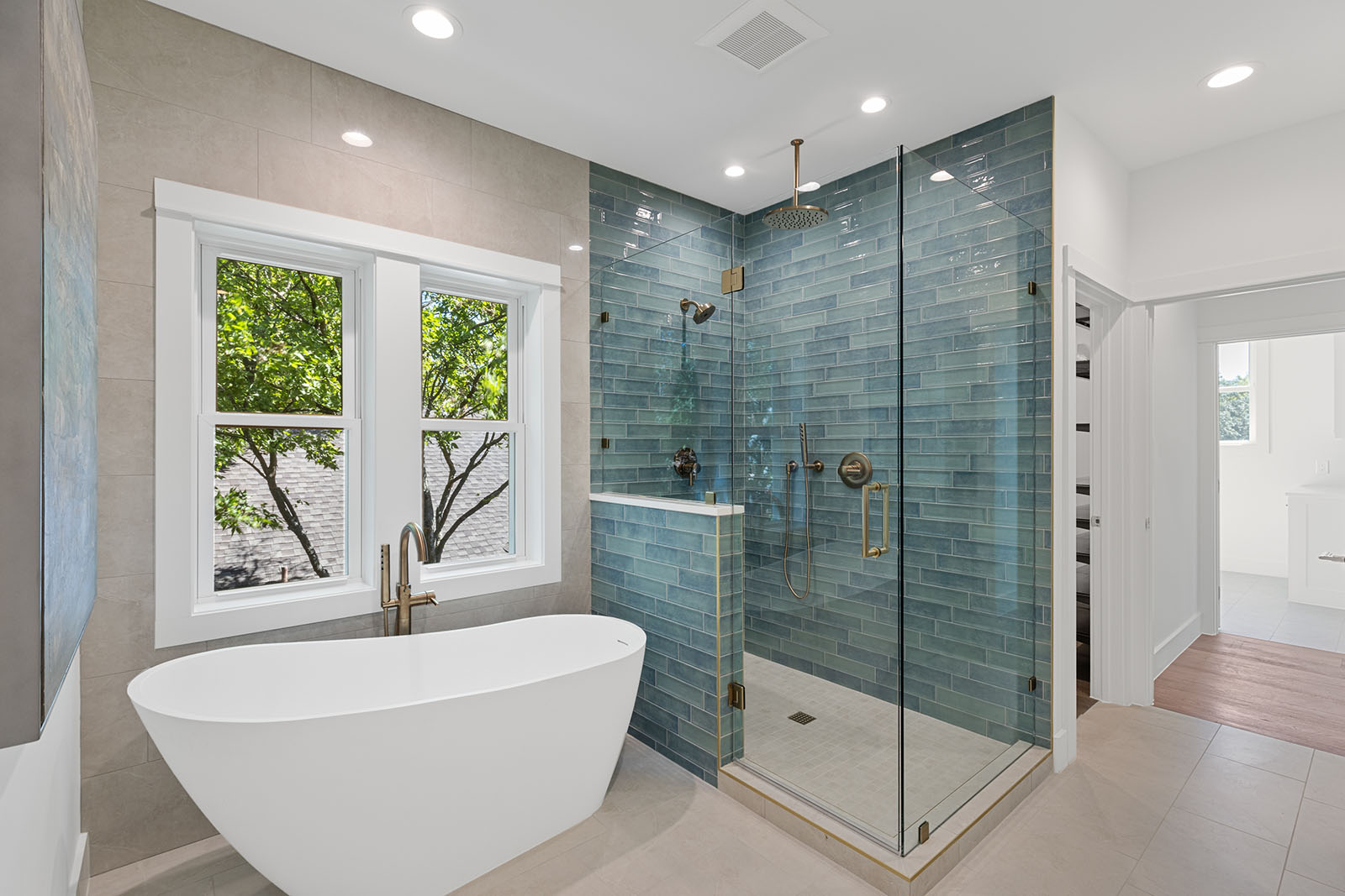 Bathroom remodel in Dallas by Renowned Group freestanding tub with blue tile walk in shower