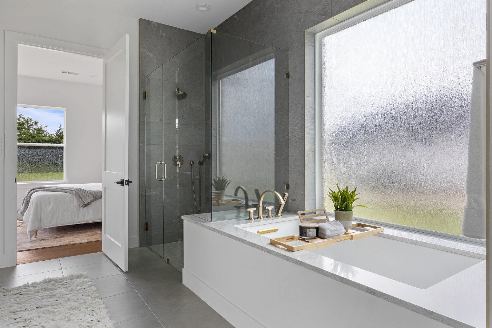 Bathroom remodel in Dallas by Renowned Group soaking tub and glass shower with gray stone tile