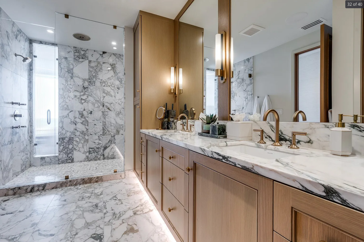 Bathroom remodel in Dallas by Renowned Group walk in marble shower with double oak vanity