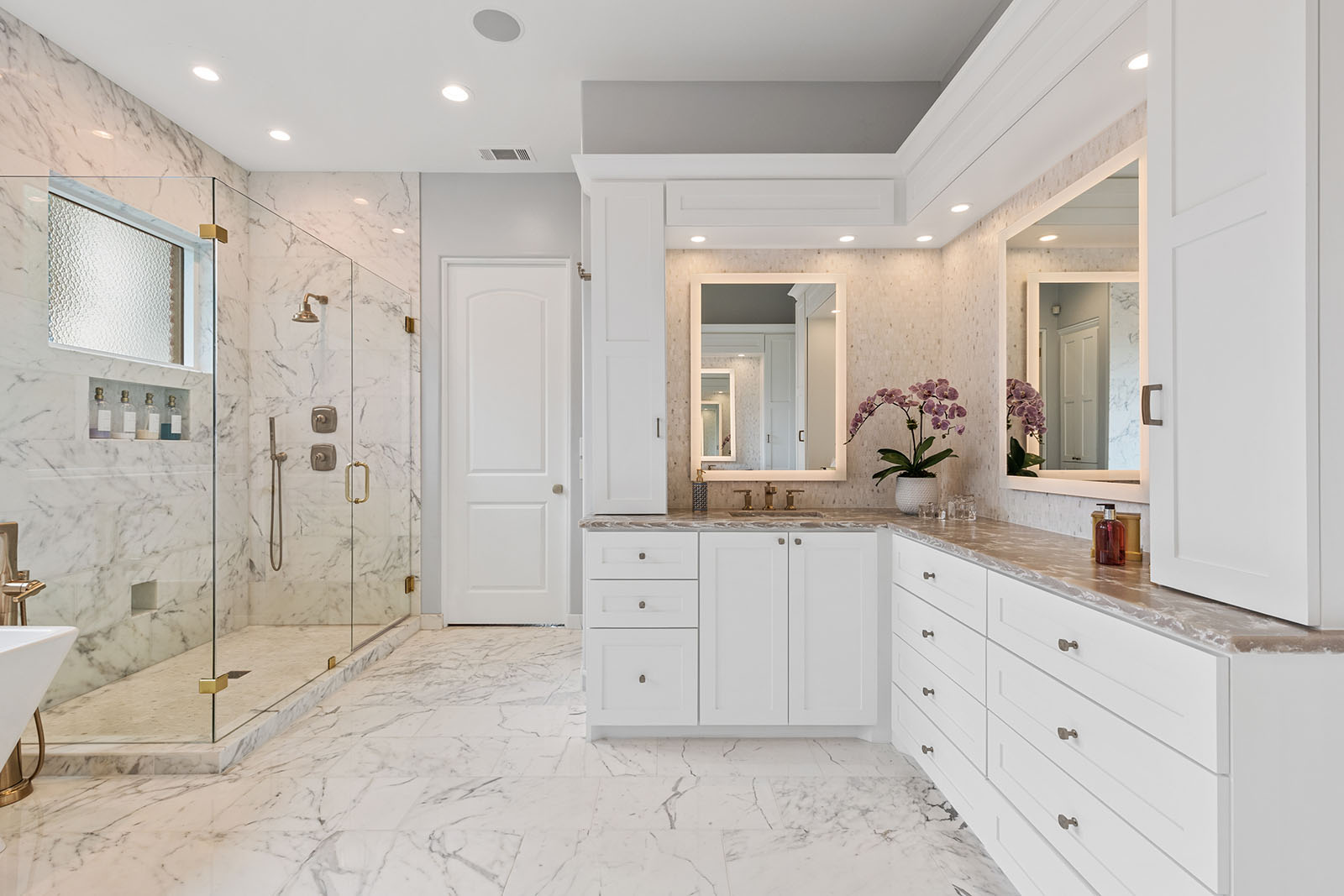 Bathroom remodel in Dallas by Renowned Group white marble bath with glass shower and double vanity