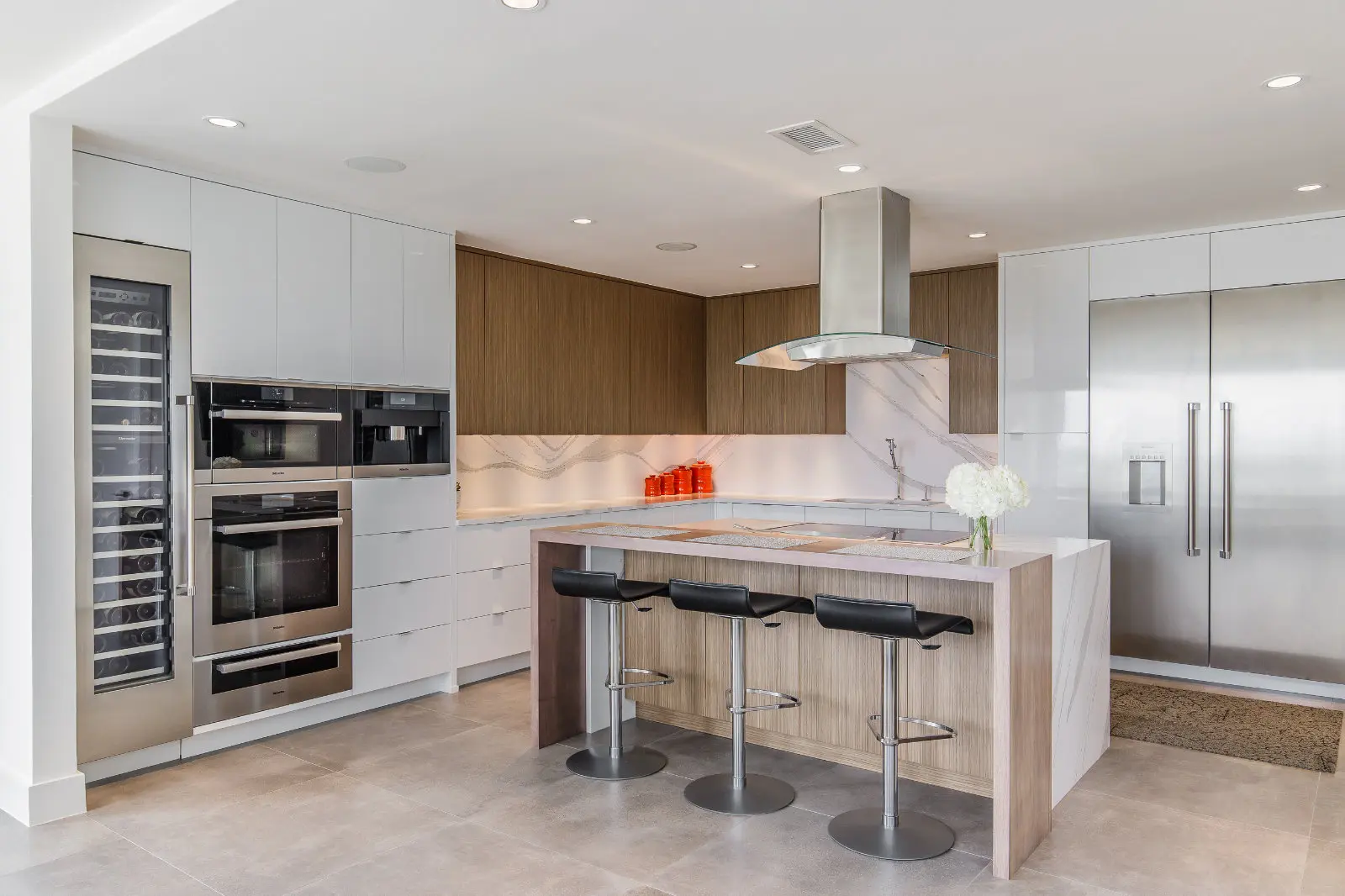 Condo Renovation in Dallas by Renowned Group modern white and walnut kitchen with waterfall island