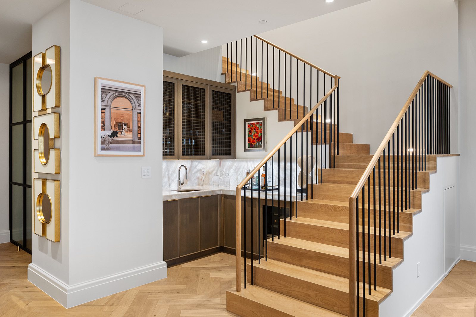 Condo Renovation in Dallas by Renowned Group white oak staircase with herringbone floors and wet bar