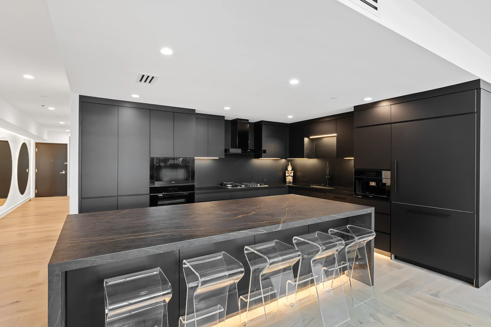 Dallas kitchen remodel by Renowned Group dark matte kitchen with acrylic bar stools