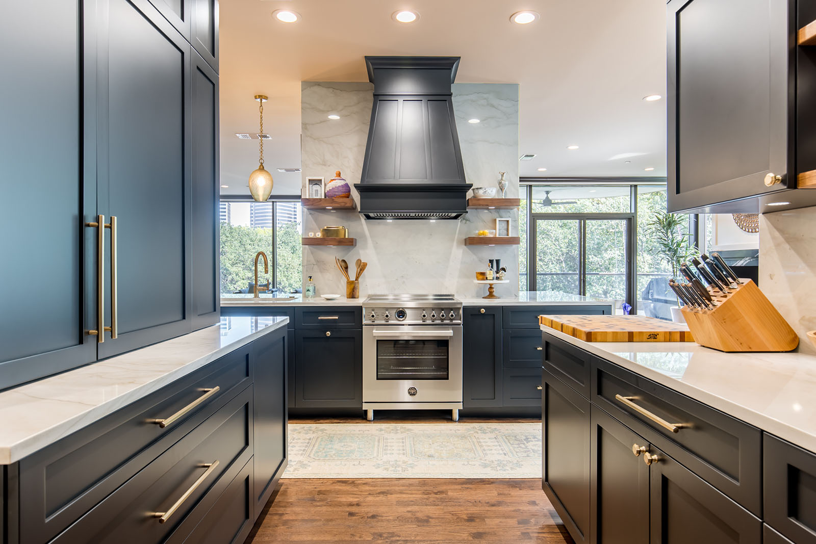 Kitchen remodel in Dallas by Renowned Group navy blue cabinets with marble countertops and stainless range