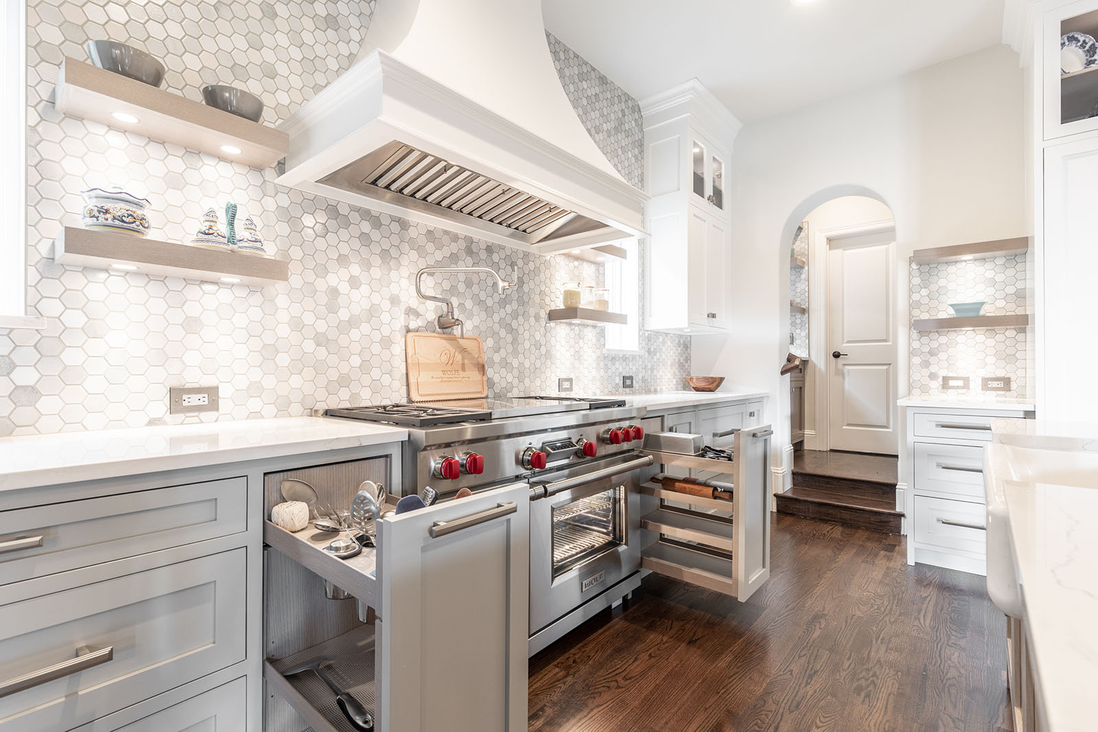 Kitchen remodel in Dallas by Renowned Group white kitchen with Wolf range and hexagon marble backsplash