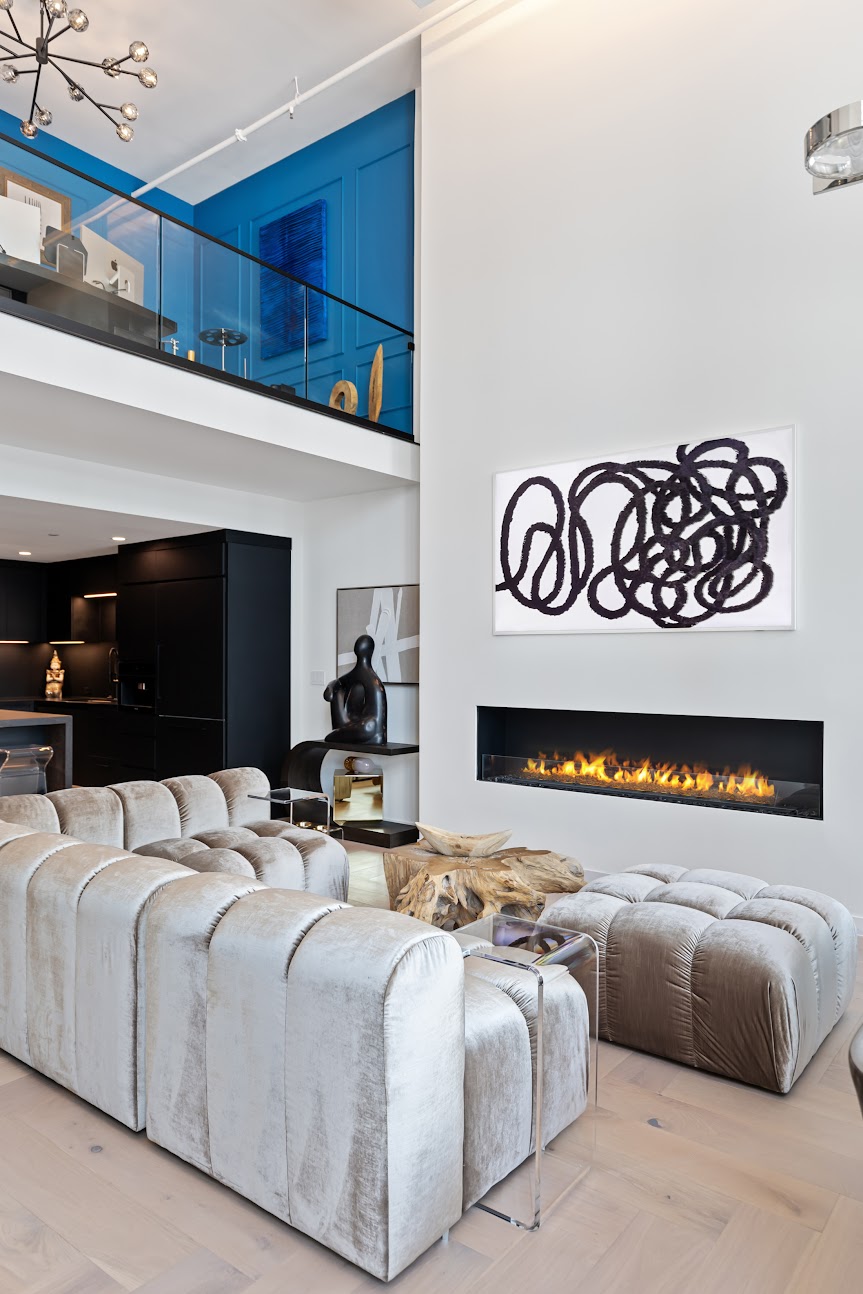 Renowned Group modern loft living room with fireplace velvet sofas and art gallery wall