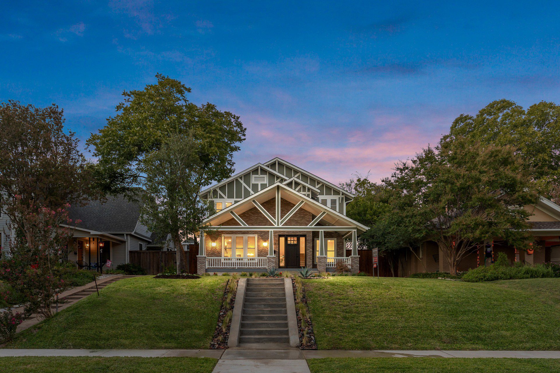 Whole Home Remodel in Dallas by Renowned Group craftsman bungalow exterior with covered porch at dusk