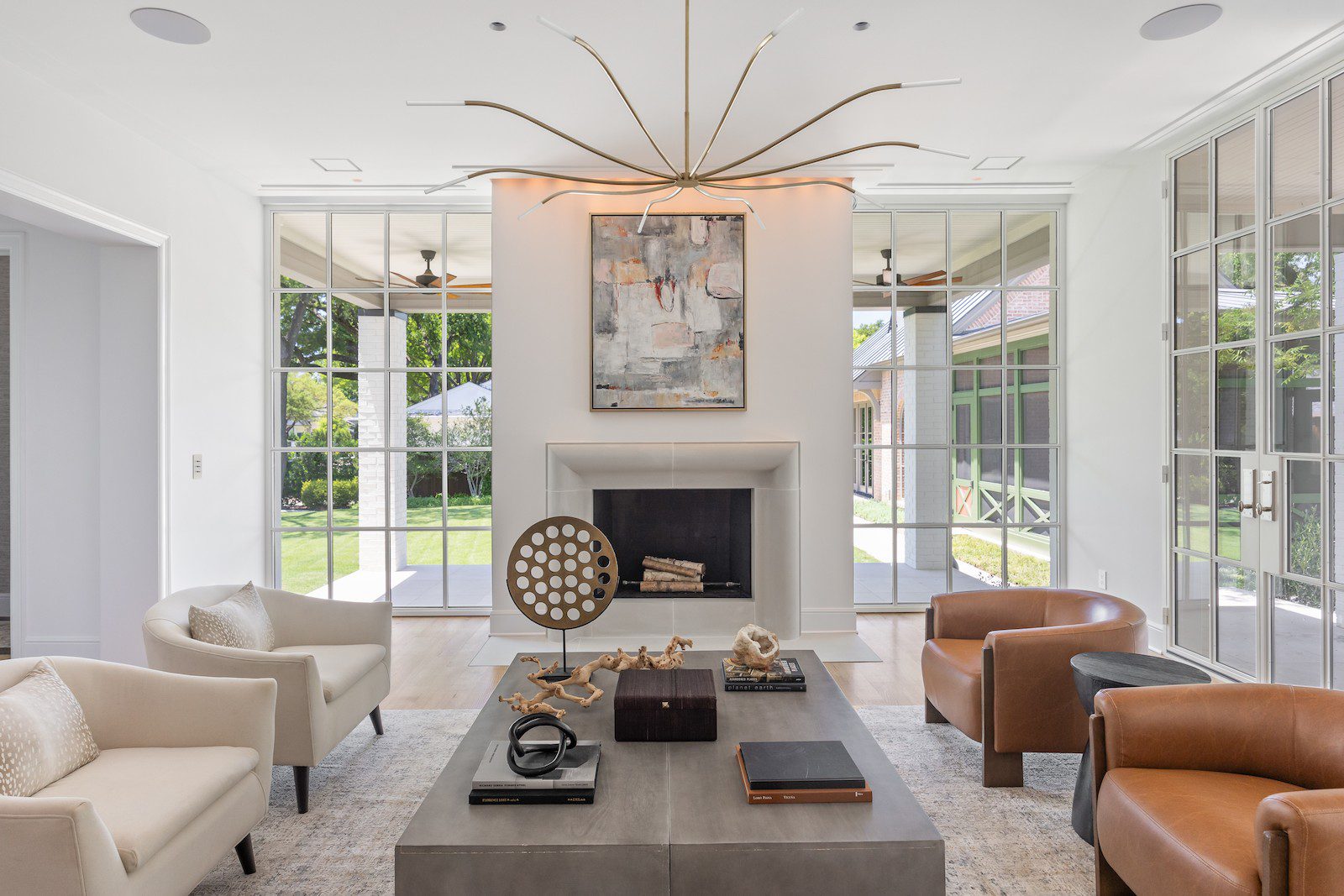 Whole Home Remodel in Dallas by Renowned Group formal living room with limestone fireplace and steel french doors