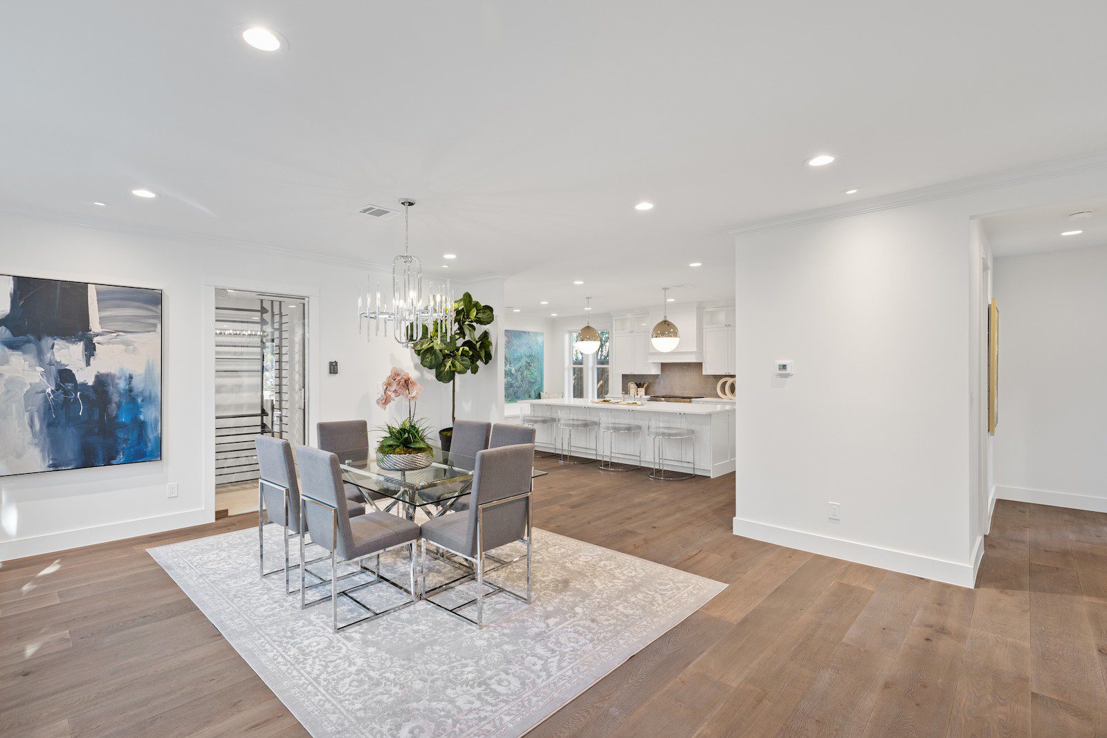 Whole Home Remodel in Dallas by Renowned Group open dining room with crystal chandelier and white oak floors