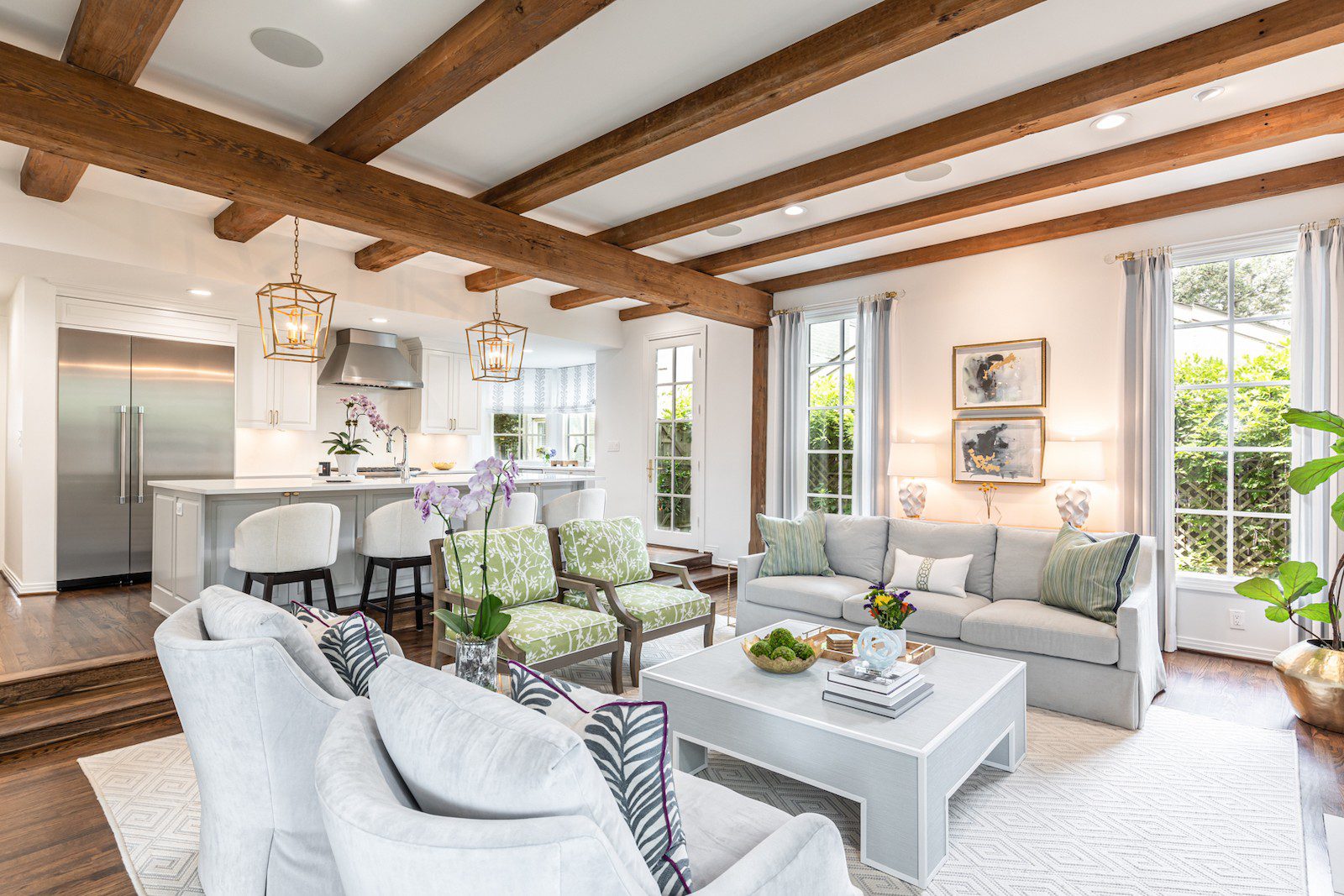 Whole Home Remodel in Dallas by Renowned Group open living room and kitchen with reclaimed wood ceiling beams