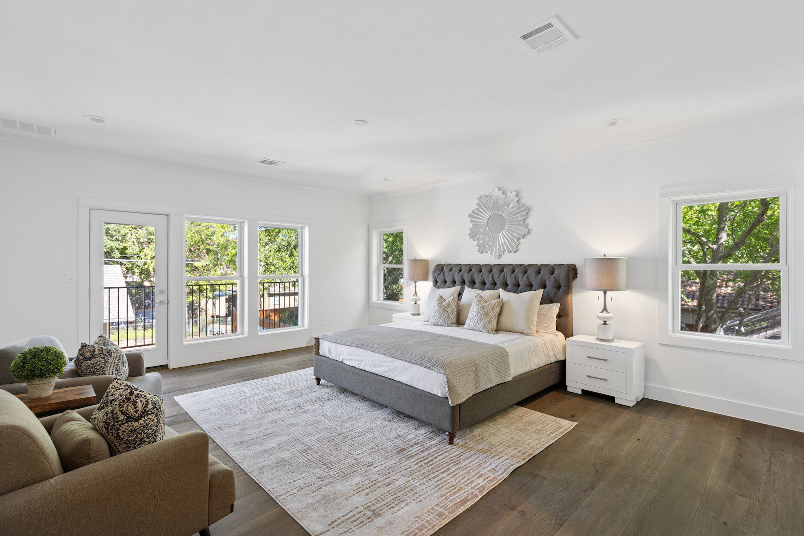 Whole Home Remodel in Dallas by Renowned Group primary bedroom with tufted headboard and balcony doors