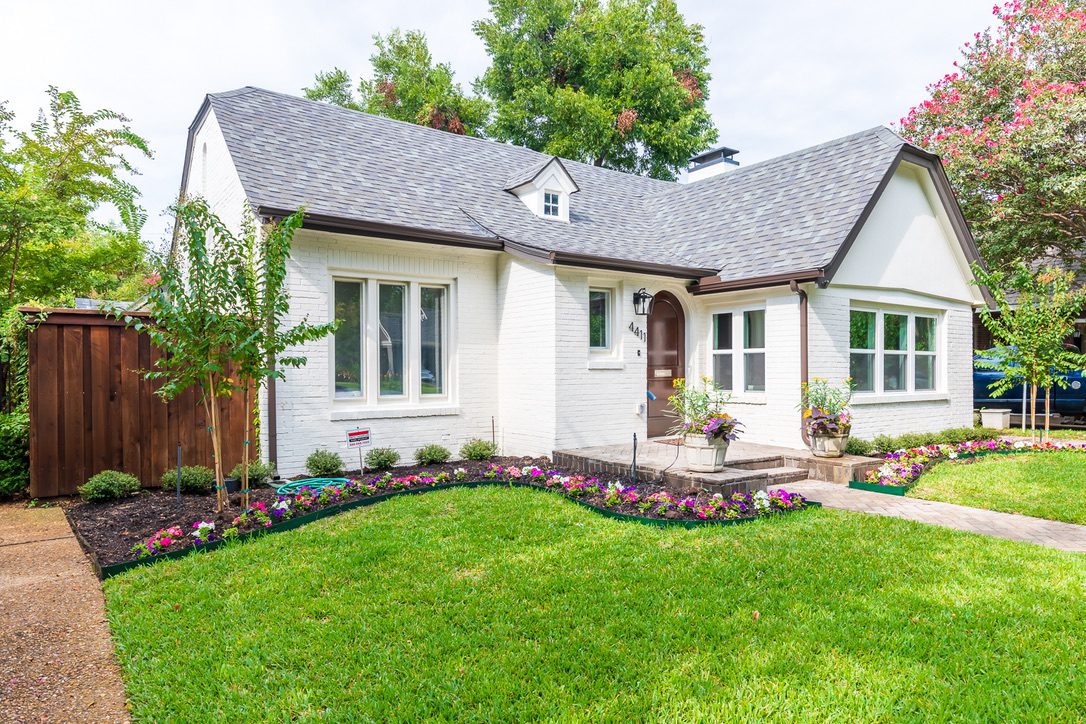 Whole Home Remodel in Dallas by Renowned Group white painted brick tudor cottage exterior with arched entry