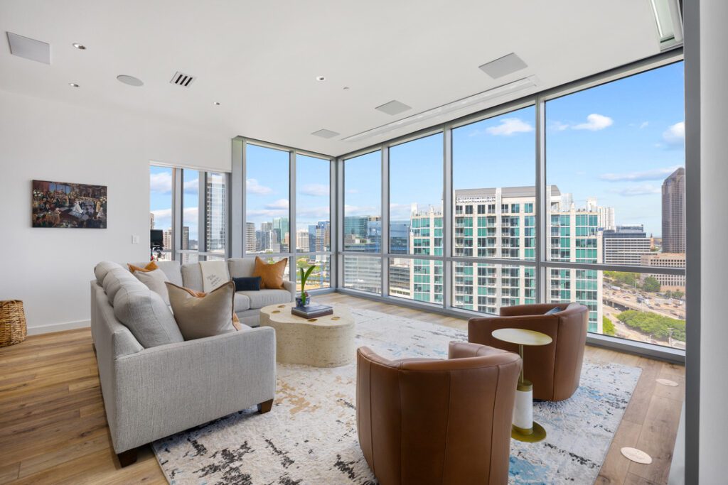 condo renovation in victory park living room corner windows with high rise city views and leather swivel chairs condo renovation in victory park living room corner windows with high rise city views and leather swivel chairs